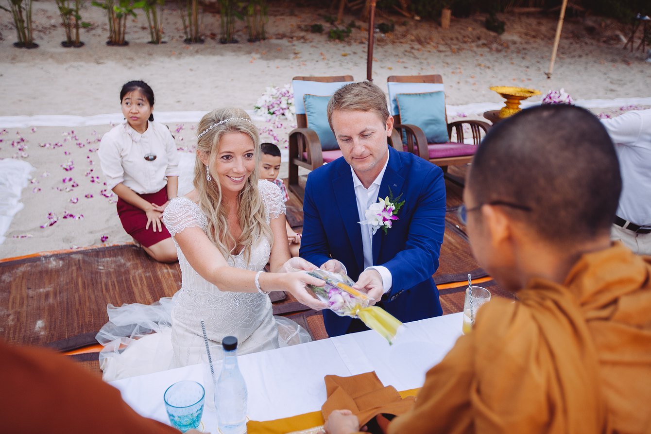 The Buddhist wedding ceremony in Thailand - bride and groom give donations to the monks